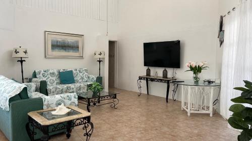 a living room with a couch and a tv at Tu Casita en Aruba in Palm-Eagle Beach