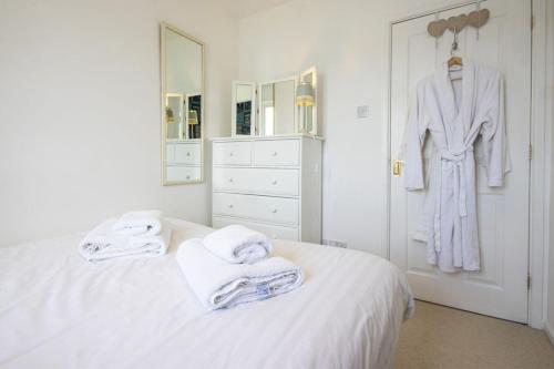 a white bedroom with towels on a bed at Windrush Lake 65, Sunset Lodge - P in South Cerney