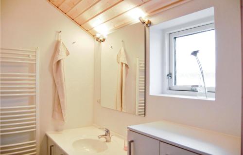 a bathroom with a sink and a mirror at 4 Bedroom Awesome Home In Rnde in Rønde