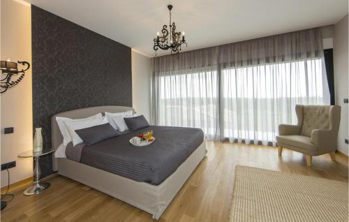 - une chambre avec un lit, une chaise et un lustre dans l'établissement Villa Verde, à Sveti Lovreč Pazenatički