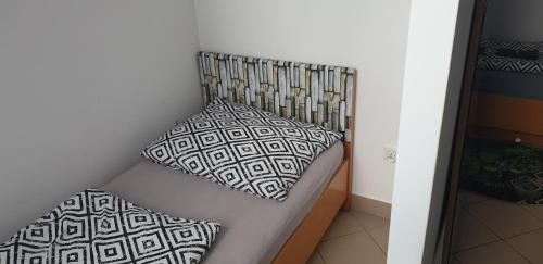 a couch with two pillows on it in a room at Strefa Zen - Pokoje z Klimatem przy Parku in Jelenia Góra