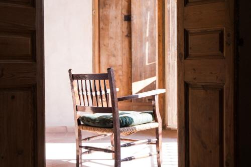 a wooden rocking chair with a pillow on it at Ca la Merce Batista in Palau-Saverdera