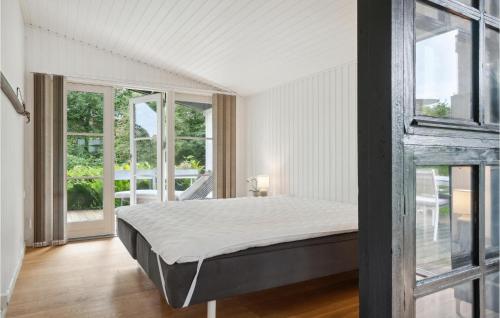 - une chambre avec un lit dans une pièce dotée de fenêtres dans l'établissement Cozy Home In Jgerspris With Jacuzzi, à Jægerspris