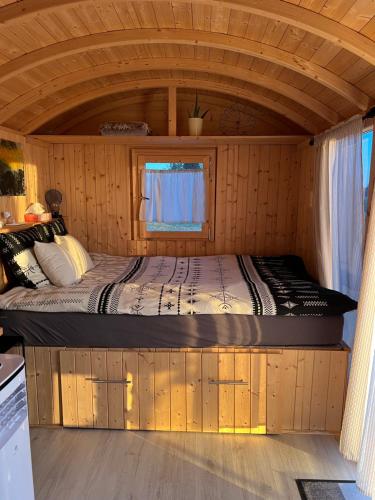 Una cama en medio de una habitación en una cabaña en Roulotte „douceur“ en Condom