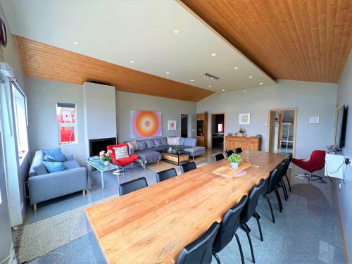una sala de estar con una gran mesa de madera y sillas en Beautiful lakehouse by the golden circle - fishing, en Selfoss