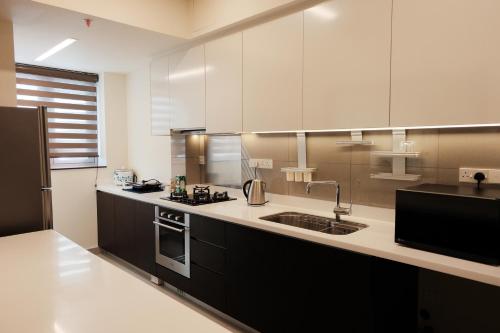 a kitchen with white cabinets and a sink at Brand new Water Front Luxury Cinnamon Suites Apartment in heart of Colombo City in Slave Island