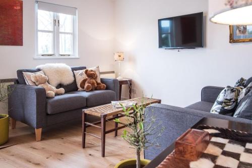 a living room with a couch and a tv at Isis Lakes 09, ArtHouse in South Cerney