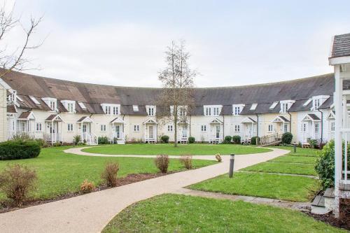 a large white building with a path in front of it at Isis Lakes 09, ArtHouse in South Cerney