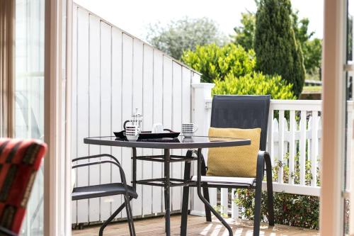 a black table and two chairs on a balcony at Isis Lakes 09, ArtHouse in South Cerney