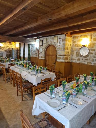 a dining room with white tables and wooden chairs at Престиж in Arbanasi