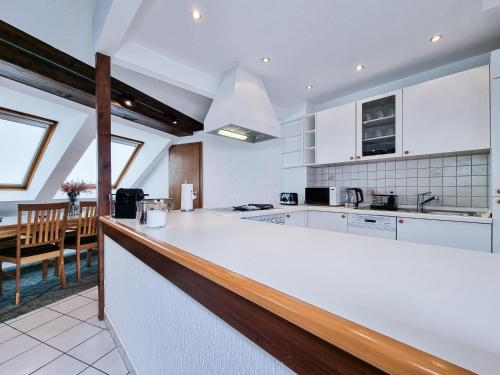 eine Küche mit einer weißen Theke und einem Esszimmer in der Unterkunft Alpha Apartments in Essen