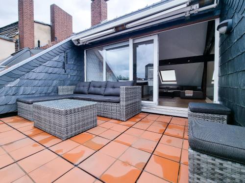 a patio with a couch and chairs on a balcony at Alpha Apartments in Essen