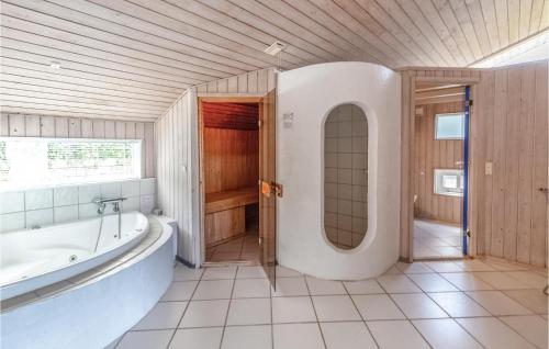 AsnæsにあるBeautiful Home In Asns With Sauna, Wifi And Indoor Swimming Poolの広いバスルーム(バスタブ、シンク付)