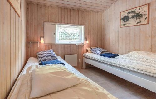AsnæsにあるBeautiful Home In Asns With Sauna, Wifi And Indoor Swimming Poolのベッド2台 木製の壁の部屋