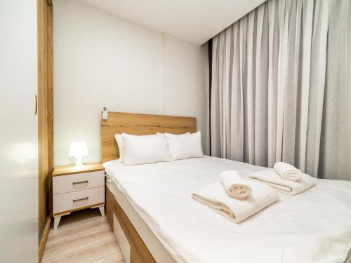 een slaapkamer met een bed met handdoeken erop bij Vacation Residence w Pool 5 min to Mall of Antalya in Antalya