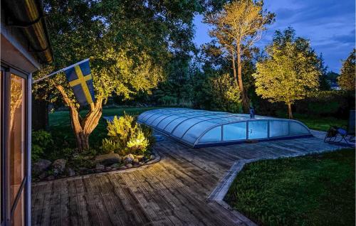 a swimming pool with a cover on a wooden deck at 3 Bedroom Beautiful Home In Klagstorp in Klagstorp