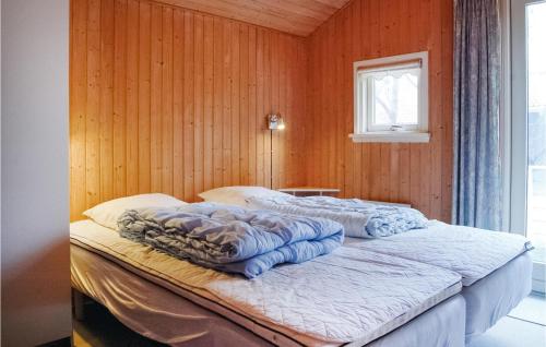 a bed in a room with a wooden wall at Stunning Home In Humble With 4 Bedrooms, Sauna And Wifi in Humble
