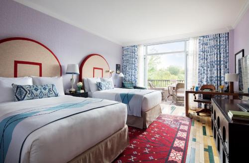 a hotel room with two beds and a balcony at Graduate Chapel Hill in Chapel Hill