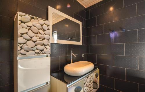 baño con azulejos negros y estufa con fregadero en Amazing Home In Ebeltoft With 3 Bedrooms, Sauna And Wifi, en Øksenmølle