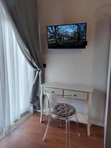 a desk with a chair and a television on a wall at Sicily Holidays Home in Calatabiano
