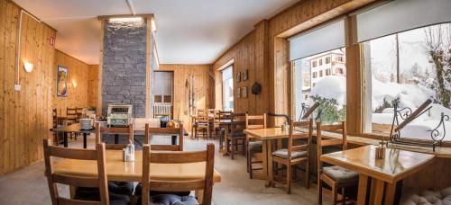 un restaurant avec des tables et des chaises et une grande fenêtre dans l'établissement Nant Morzine, à Morzine