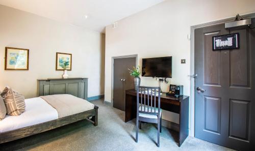 a bedroom with a bed and a desk and a television at Eton House - Self Check-In, Ensuite Rooms & Self-Catering Studios in Yeovil