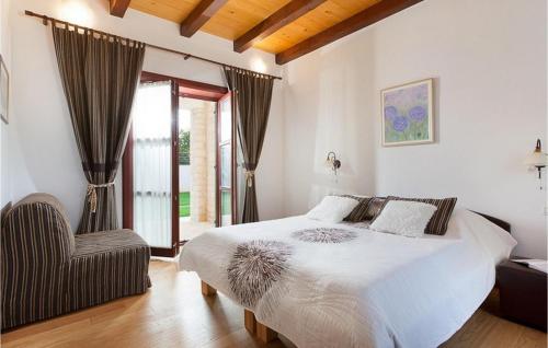 - une chambre avec un grand lit blanc et une chaise dans l'établissement Villa Nikola, à VeliGolji