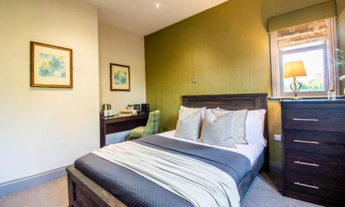 a bedroom with a bed and a desk and a window at Eton House - Self Check-In, Ensuite Rooms & Self-Catering Studios in Yeovil