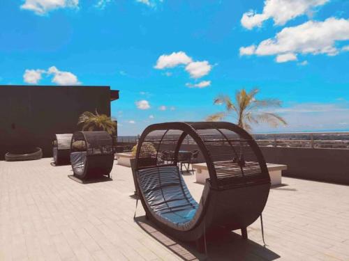 a bench sitting on a patio overlooking the ocean at Hanns&FreeWIFI&Washer+Pool@SunshineComfortHMStay3 in Sibu