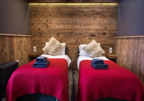 two beds in a room with red and blue blankets at Nant Morzine in Morzine