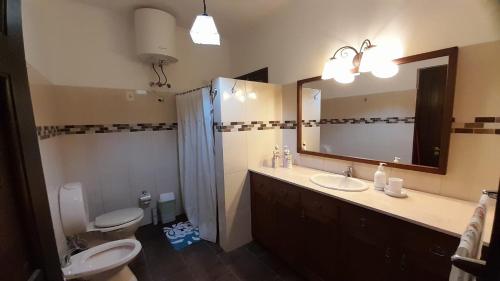 ein Badezimmer mit einem Waschbecken, einem WC und einem Spiegel in der Unterkunft Casa una habitación in Colonia del Sacramento