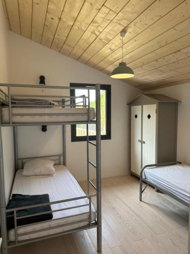 1 Schlafzimmer mit 2 Etagenbetten und einem Fenster in der Unterkunft Maison bois neuve tout confort, au calme in Messanges