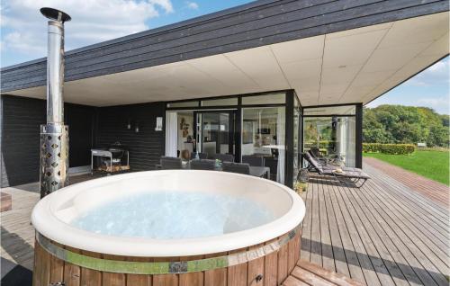 a bath tub on a deck with a house at Holiday Home Haderslev With Sea View 12 in Kelstrup Strand