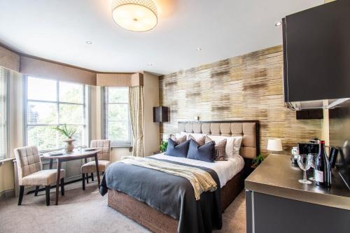 a bedroom with a bed and a table with chairs at Eton House - Self Check-In, Ensuite Rooms & Self-Catering Studios in Yeovil