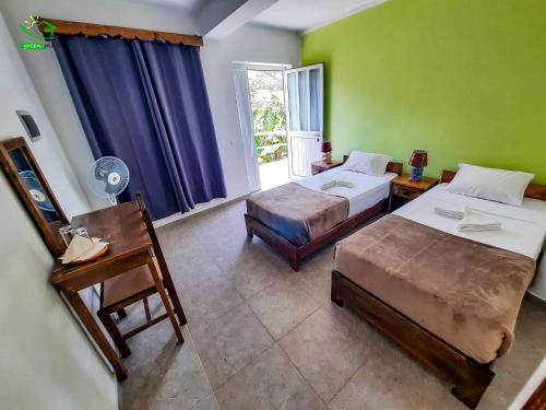 a hotel room with two beds and a window at Pousada Green Place in Ribeira Grande