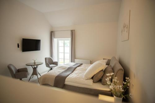 a bedroom with a bed and a tv in it at Landgut Rastede Hostemost in Rastede