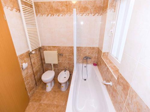 a bathroom with a tub and a toilet and a tub at Apartment in Njivice/Insel Krk 27659 in Njivice