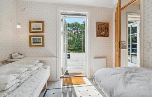 a bedroom with a bed and a sliding glass door at Trojlhyttan in Bedegård