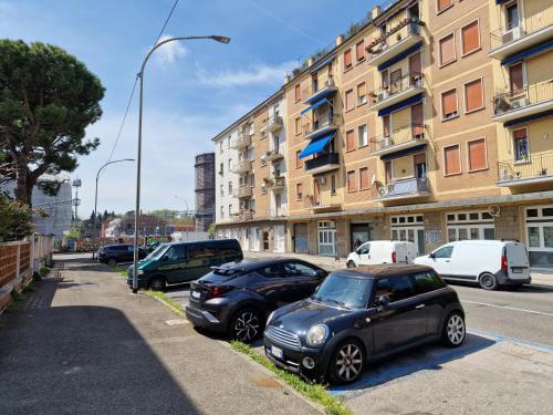 ボローニャにあるLa Ca' Pezzana Affittaly Apartmentsの建物前に停車する車両群