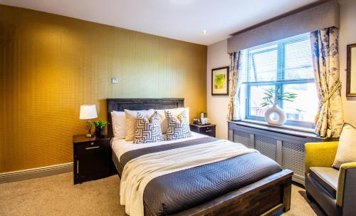 a bedroom with a bed and a window and a chair at Eton House - Self Check-In, Ensuite Rooms & Self-Catering Studios in Yeovil