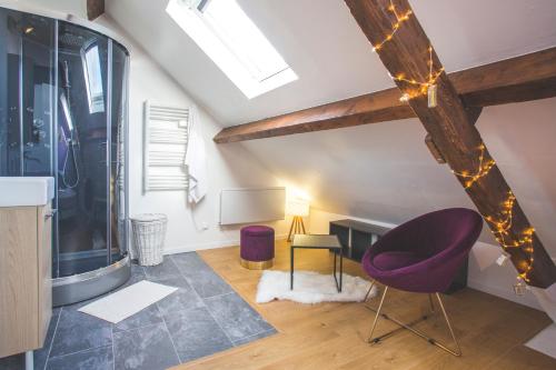 Sala de estar con silla morada y mesa en Colocation de luxe à Tourcoing avec jardin en Tourcoing