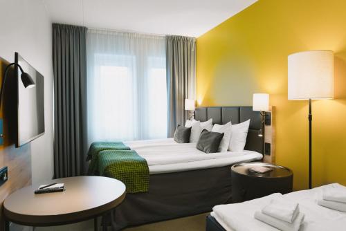 a hotel room with a large bed and a table at Quality Hotel Winn Haninge in Haninge
