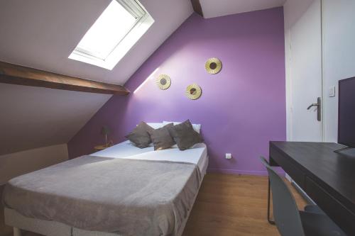 トゥールコワンにあるColocation de luxe à Tourcoing avec jardinの紫の壁のベッドルーム1室、ベッド1台が備わります。