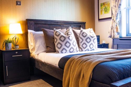 a bedroom with a bed with pillows on it at Eton House - Self Check-In, Ensuite Rooms & Self-Catering Studios in Yeovil