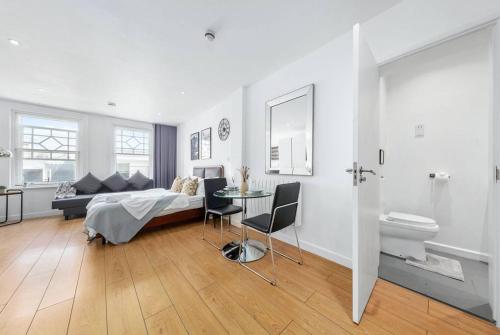 - une chambre avec un lit et une table ainsi qu'une salle de bains dans l'établissement Stylish Piccadilly 1 BR Flat in London VR2, à Londres