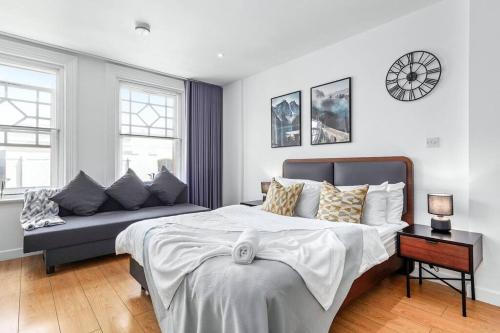 - une chambre avec un grand lit et un canapé dans l'établissement Stylish Piccadilly 1 BR Flat in London VR2, à Londres