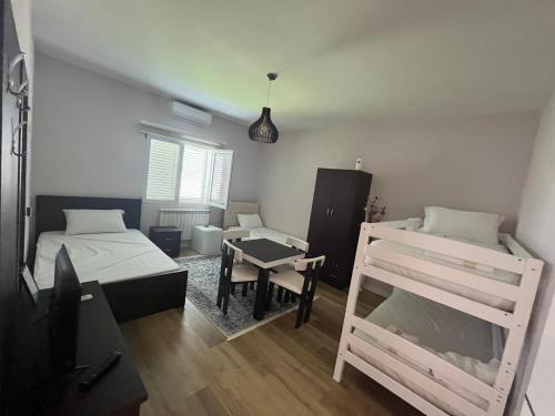 Pokój z 2 łóżkami, stołem i biurkiem w obiekcie Bujtina cela w mieście Berat