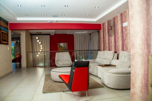 a living room with a couch and a red chair at Kliprivier Guest House in Tokoza