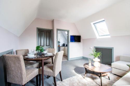 a living room with a table and chairs and a couch at Eton House - Self Check-In, Ensuite Rooms & Self-Catering Studios in Yeovil