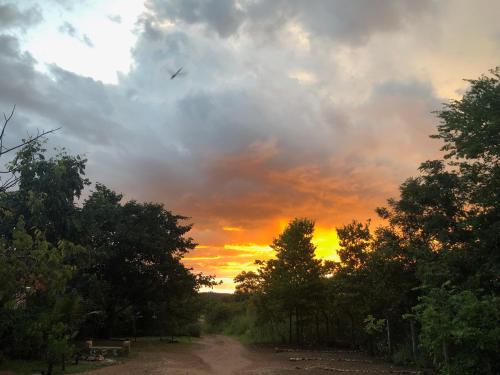 a dirt road with a sunset in the sky at Espaço Shanti - Chalés in Sao Jorge
